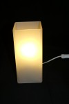 Lampe à poser en verre glacé blanc allumée